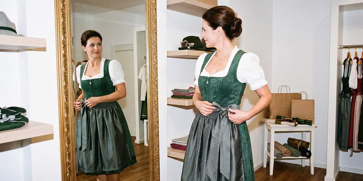 Frau in einem Stockerpoint Dirndl vor dem Spiegel