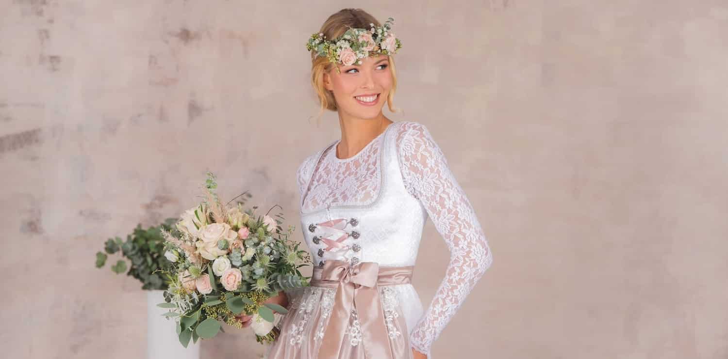 Frau in Hochzeitsdirndl und Blumen